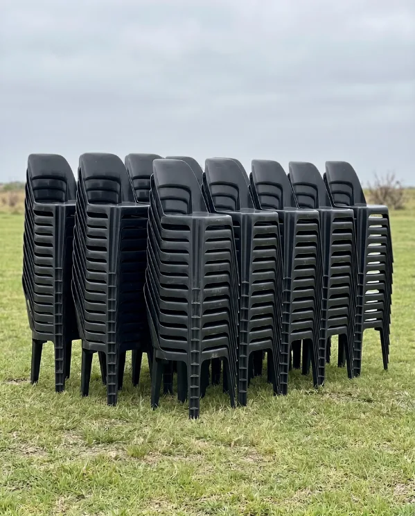 Black plastic chairs stacked and ready for hire by Luvo Events in Durban